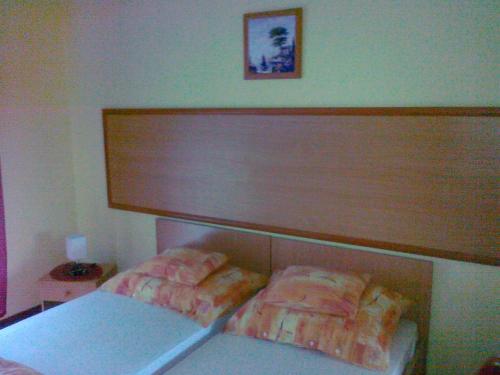 a bedroom with a large headboard and two beds at Zsófia Panzió Pápa in Pápa