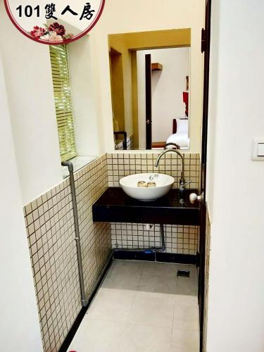 a bathroom with a sink and a mirror at Kinmen Huquian 58 in Jinhu