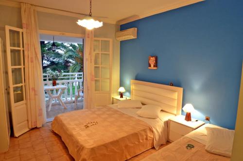 Un dormitorio con una cama con una pared azul. en Elea Hotel Apartments and Villas, en Argassi