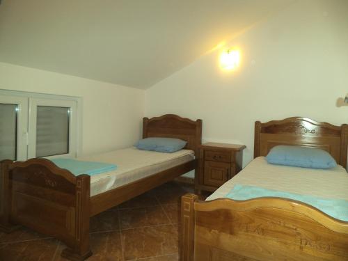 a bedroom with two beds and a mirror at Apartments Stanjević in Tivat