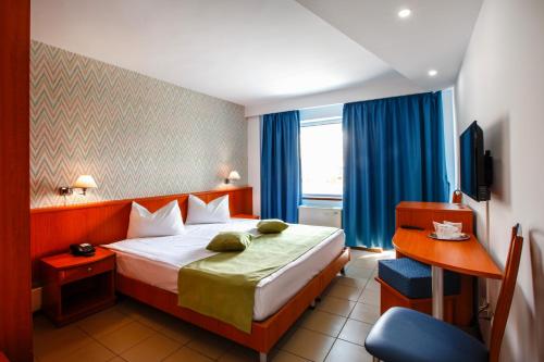 a hotel room with a bed and a chair at Hotel Apollo in Mamaia