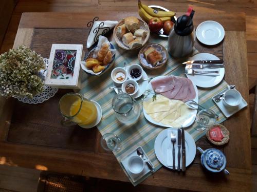 uma mesa com alimentos e bebidas para o pequeno almoço em Cabaña La Strega em Tandil