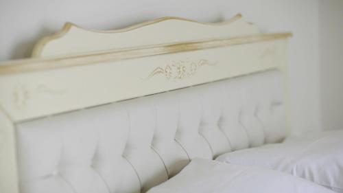 a white bed with a white headboard and white pillows at Pensiunea Anastasia fosta Sofia in Remetea Mare