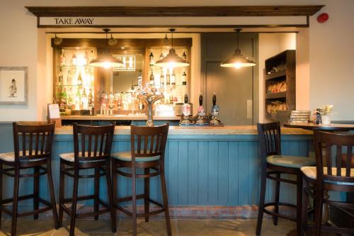 a bar with wooden chairs and a blue counter at The Saracens Head in Stafford