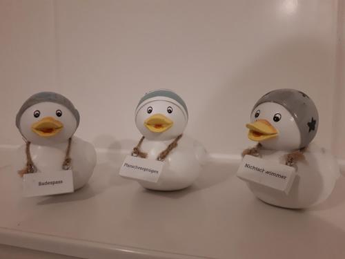three rubber ducks sitting on top of a table at Ferienwohnungen Auf der Düne in Cuxhaven