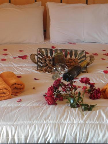 a bed with a bunch of flowers and a bottle of wine at Koustenis Village in Dhimitsana