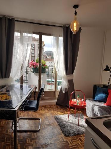 een woonkamer met een tafel en een groot raam bij Studio 87 Avenue de Paris in Villejuif