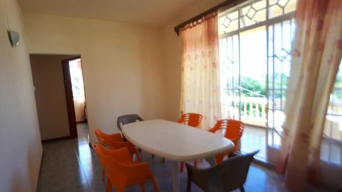 a table and chairs in a room with a window at Allamanda Apartments - 100m Bain Boeuf Beach in Bain Boeuf