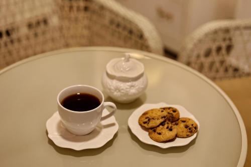 a cup of coffee and cookies on a table at Tbilisi View Hotel in Tbilisi City