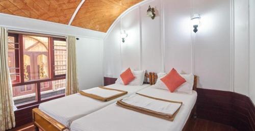 2 Einzelbetten in einem Zimmer mit Fenster in der Unterkunft Sivaranjani Hotel in Hosur