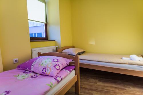 a bedroom with two bunk beds with purple sheets at Apartments & Rooms Fountain in Bihać