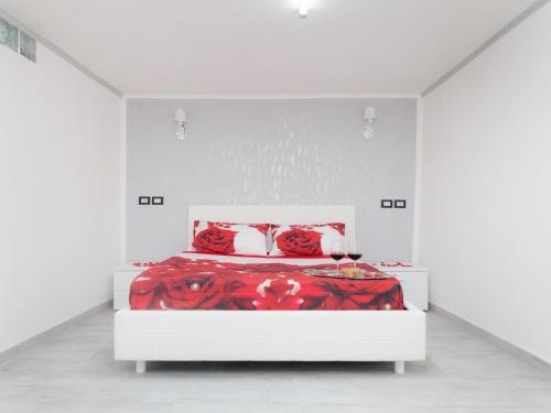 埃爾科拉諾的住宿－Short Lets Lulù，白色卧室配有红色的床和红色枕头