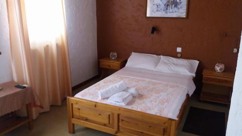 a bedroom with a bed with two towels on it at Antikristo Rooms in Karteros