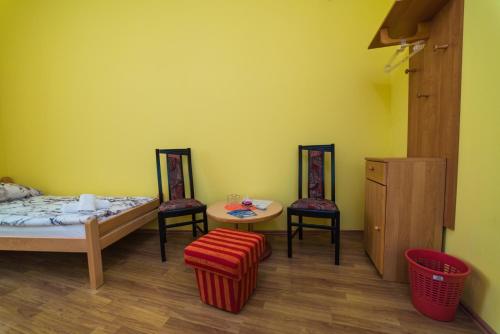 a room with two beds and a table and chairs at Apartments & Rooms Fountain in Bihać