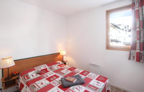 - une chambre avec un lit doté d'une couverture rouge et d'une fenêtre dans l'établissement Résidence Odalys Les Sybelles, à Saint-Sorlin-dʼArves