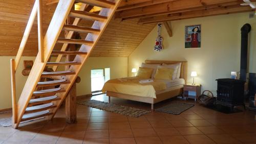 a bedroom with a bed and a wooden staircase at Zagroda Cztery Wiatry in Sądry