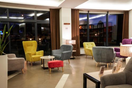 a waiting room with colorful chairs and tables at Vestil Hotel in Piotrków Trybunalski