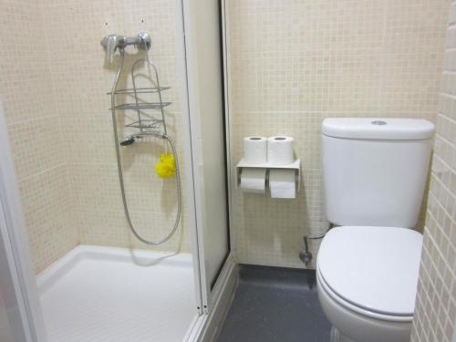 La salle de bains est pourvue d'une douche et de toilettes. dans l'établissement Hostel Prime Guimaraes, à Guimarães