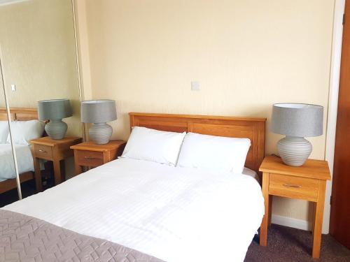 a bedroom with a bed and two lamps on tables at Glenkerry in Ingoldmells