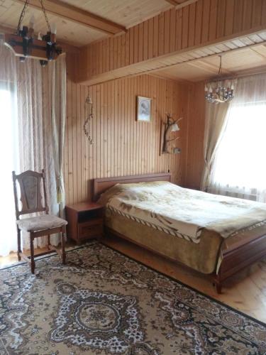 a bedroom with a large bed and a chair at U Olgi in Truskavets