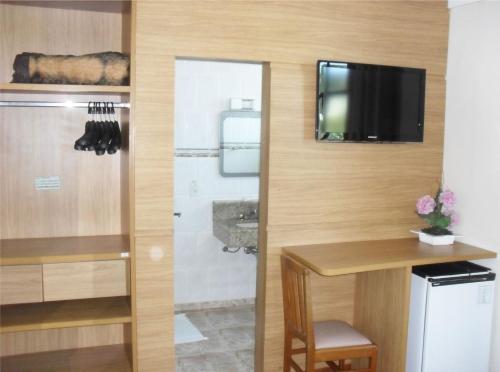 a bathroom with a shower and a television on a wall at Parque Hotel de Lambari in Lambari