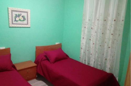 ルーゴにあるHospedaje Mendezのベッドルーム(紫のシーツを使用したベッド2台付)
