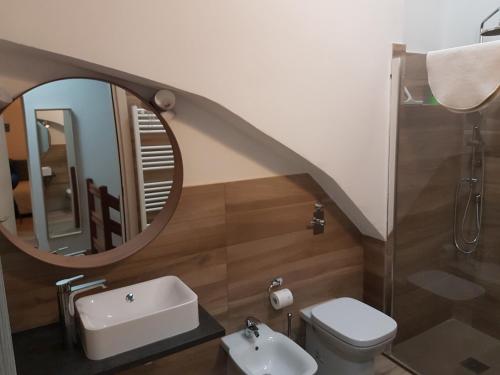 W łazience znajduje się toaleta z umywalką i lustro. w obiekcie La Corte sul Naviglio w mieście Corsico