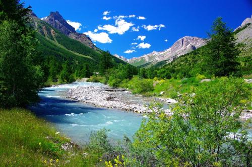 a river in a valley with mountains in the background at Le Grand Aigle Hotel & Spa**** in La Salle-les-Alpes