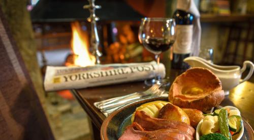 a plate of food on a table with a glass of wine at Shibden Mill Inn in Halifax
