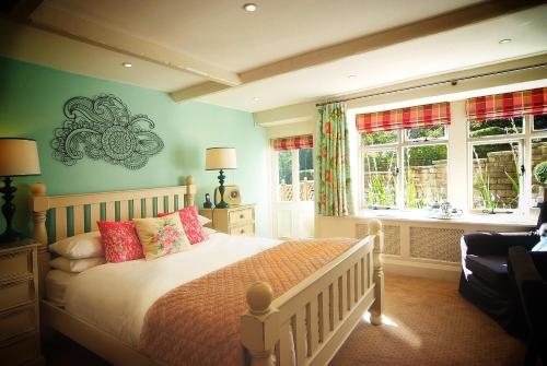 a bedroom with a bed and two windows at Shibden Mill Inn in Halifax