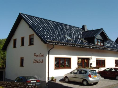 a white building with cars parked in front of it at Pension Ulrich in Dahlem