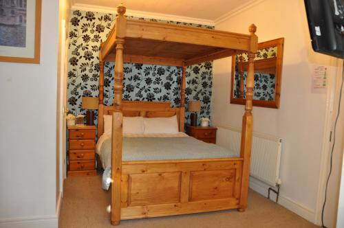 a bedroom with a wooden bed with a canopy at Walcot House in Fawley