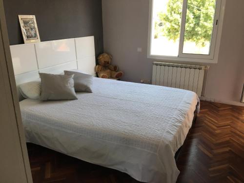 ein Schlafzimmer mit einem weißen Bett und einem Teddybären in der Unterkunft Villa Masnou Homelydays in El Carrer del Canonge