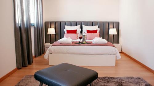 a bedroom with a large bed with red pillows at Ana's Apartments in Sines