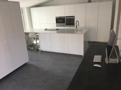 eine leere Küche mit weißen Schränken und einem Waschbecken in der Unterkunft Villa Masnou Homelydays in El Carrer del Canonge