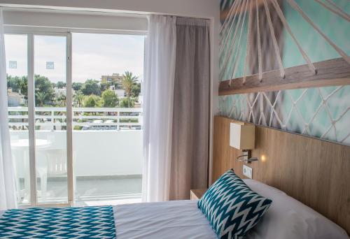 a bedroom with a bed and a large window at BQ Sarah -Adults Only in Can Picafort