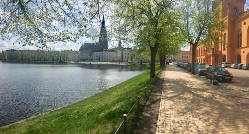 una strada accanto a un fiume con auto parcheggiate di Schwerin Apartment am Pfaffenteich a Schwerin