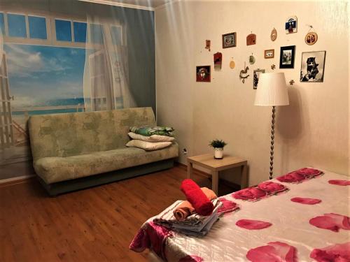 Una mujer acostada en una cama en una habitación con sofá en Apartment on Mira 34-a, en Mytishchi