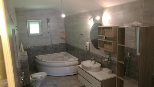 ein Badezimmer mit einer Badewanne, einem WC und einem Waschbecken in der Unterkunft Vip villa فيلا في اي بي in Sarajevo