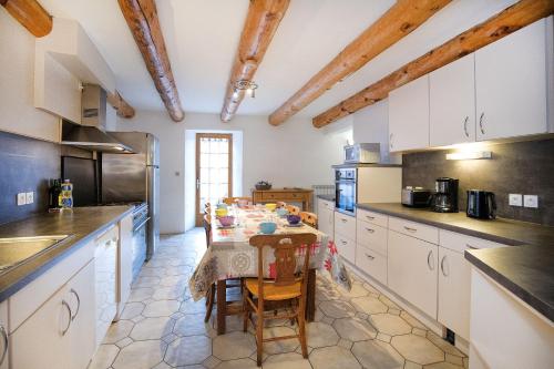 a kitchen with a table and some chairs in it at Le Chalet du Villard in Saint-André