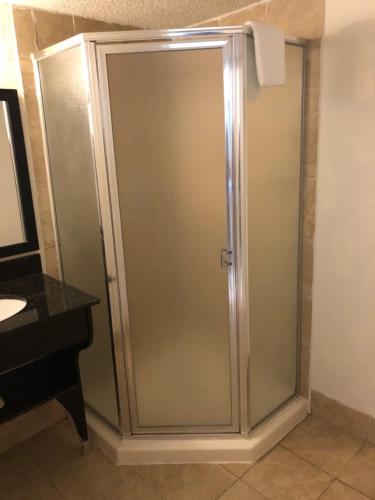 a glass shower door in a bathroom next to a sink at Super 8 by Wyndham Augusta in Augusta