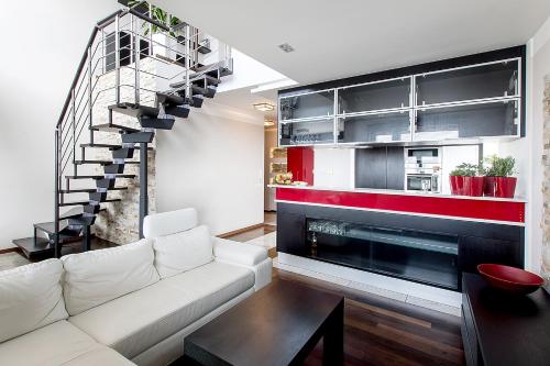 a living room with a white couch and a fireplace at Apartament z Widokiem in Poznań