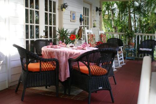a table on a porch with a pink table cloth at Sabal Palm House Bed and Breakfast in Lake Worth