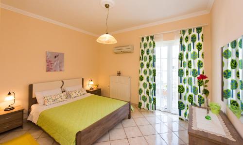 a bedroom with a bed and a large window at House of Velenia, Family Apt 15' from Corfu center in Corfu