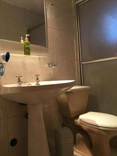uma casa de banho com um lavatório e um WC em Hotel Kolping San Ambrosio em Linares
