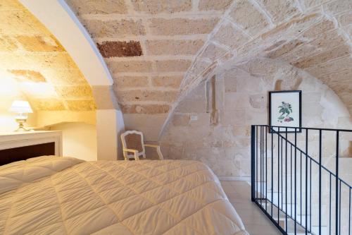 レッチェにあるDimora dei Baroniの石壁のベッドルーム1室(ベッド1台付)