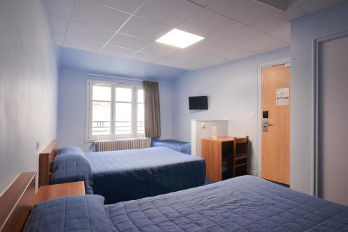 Cette chambre comprend 2 lits et une fenêtre. dans l'établissement Hotel Le Petit Duquesne, à Nantes