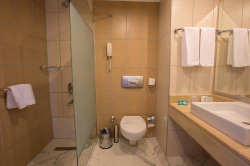 La salle de bains est pourvue de toilettes, d'un lavabo et d'une douche. dans l'établissement Side Aquamarin Resort & Spa, à Sidé