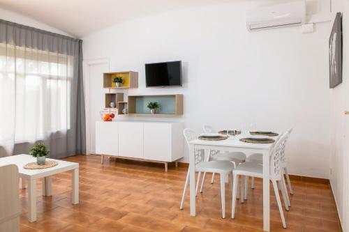 a living room with a white table and chairs at RVHotels Apartamentos Benelux in Platja  d'Aro