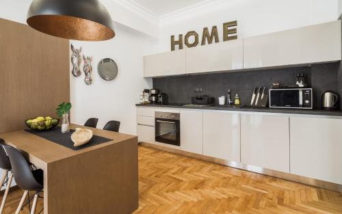 kuchnia z białymi szafkami i drewnianą podłogą w obiekcie Acropolis Executive Suite w Atenach